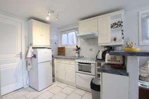 una cocina con electrodomésticos blancos y armarios blancos en Celhaya, en Mouguerre