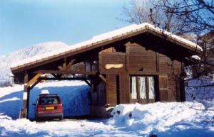 una casa con un coche aparcado en la nieve en Le Petit Paddock en Saint-Gervais-les-Bains