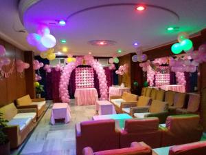 una habitación con globos rosa y púrpura y un escenario en Hotel Mahalaxmi Indo Myanmar en Guwahati