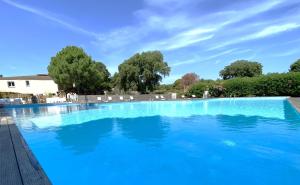 a large swimming pool with blue water at Appart Cala Rossa - T2 Porto-Vecchio in Lecci