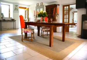 a dining room with a wooden table and chairs at Ferme de la Cochette in Montcel