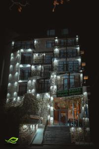 - un bâtiment éclairé avec des escaliers devant lui la nuit dans l'établissement Paradise Borjomi Hotel, à Bordjomi