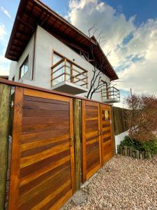 une maison avec des portes de garage en bois devant elle dans l'établissement Tronco do Ipê Hospedagem, à Alto Paraíso de Goiás