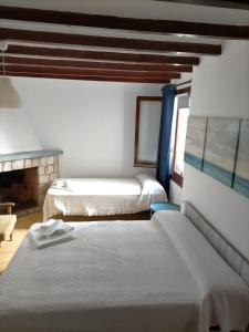 1 dormitorio con 2 camas y chimenea en Casa Barrilets, en Benissa