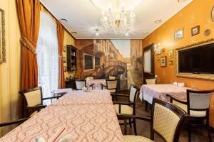 a dining room with tables and chairs and a chandelier at Luxury Boutique Andreevskiy in Lviv