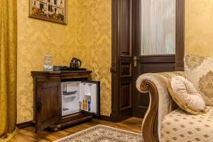 soggiorno con sedia e piccolo frigorifero di Luxury Boutique Andreevskiy a Lviv