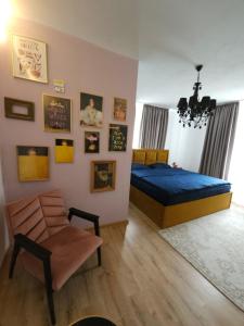 1 dormitorio con 1 cama azul y 1 silla en Pensiunea Mango, en Predeluţ