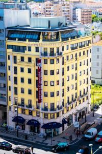 un edificio amarillo con un cartel encima en America Diamonds Hotel, en Lisboa