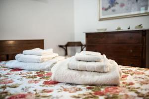 three towels are stacked on top of a bed at Patty’s House [Centro storico a 5 min] in Pesaro