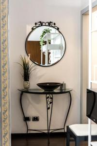 einen Spiegel an einer Wand über einem Tisch mit einem Waschbecken in der Unterkunft Patty’s House [Centro storico a 5 min] in Pesaro