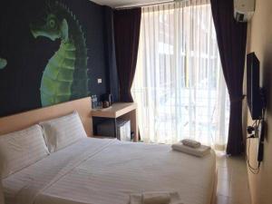 Ban Khlong Haeng的住宿－GO INN Krabi Aonang Beach โกอินน์ กระบี่ อ่าวนาง，卧室配有一张挂着龙画的墙壁床。