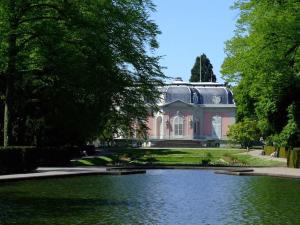 ein großes Haus mit einem Teich davor in der Unterkunft Perfektes Appartement am Düsseldorfer Rhein in Düsseldorf