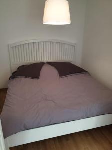 ein Bett in einem Schlafzimmer mit einer Lampe darüber in der Unterkunft Perfektes Appartement am Düsseldorfer Rhein in Düsseldorf