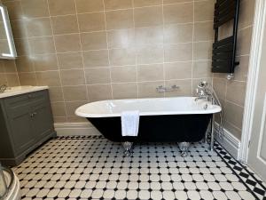 a bathroom with a tub and a tiled floor at Chester Court Hotel in Chester