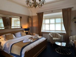 a bedroom with a bed with a mirror and a chair at Chester Court Hotel in Chester
