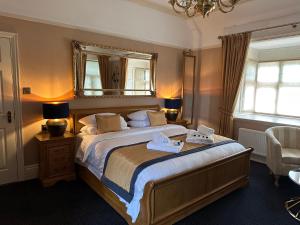een slaapkamer met een groot bed met een spiegel aan de muur bij Chester Court Hotel in Chester