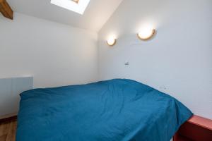 una camera con un letto blu e due luci sul muro di Le Crey du Quart a Valmeinier Altre 13 foto