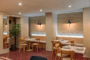 a restaurant with tables and chairs and two windows at Vermont Boutique Hotel in Tbilisi City
