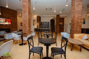 - un restaurant avec des tables, des chaises et un canapé dans l'établissement Paradise Borjomi Hotel, à Bordjomi