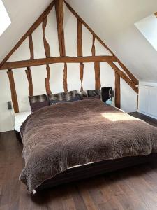 a bedroom with a large bed in a attic at Maison familiale à la campagne in Dollot +26 photos