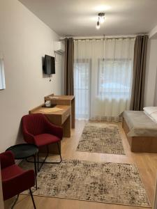 Schlafzimmer mit einem Bett, einem Schreibtisch und Stühlen in der Unterkunft Casa BABI in Căciulata