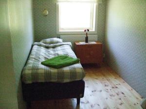 a small bedroom with a bed and a window at Allsta Gård Kretsloppshuset B&B in Bjärtrå