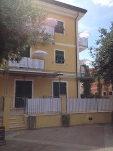 a yellow building with a white fence in front of it at Creuza de Ma in Tellaro