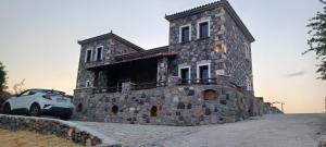 Molivos Castleview Luxury Villa في ميثيمنا: سيارة متوقفة أمام مبنى حجري