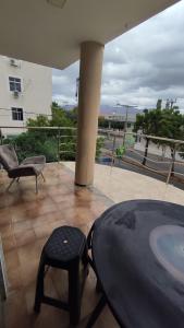 a patio with a chair and a stool on a balcony at Hotel Nacional in Sobral