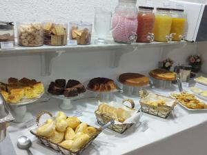 a buffet filled with different types of cakes and pastries at Mônaco Hotel in Juiz de Fora