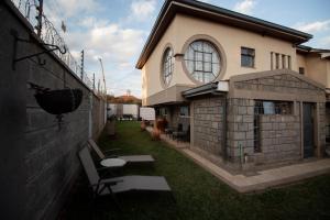 un patio trasero de una casa con un edificio en opal oasis, en Kahawa