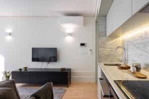 a kitchen with a sink and a tv on a wall at ORM Batalha Apartments in Porto