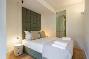 a bedroom with a bed with two towels on it at ORM Batalha Apartments in Porto