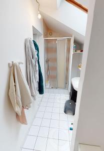 ein Bad mit Dusche und weißem Fliesenboden in der Unterkunft "A la ferme moderne" - campagne rennaise in Chantepie