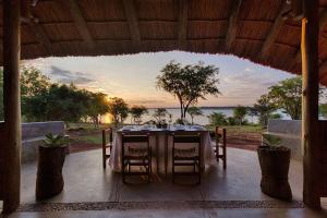 a table on a patio with a view of the ocean at Covane Community Lodge in Lagoa Nova