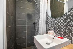 Nightcap at Rex Hotel في أديلايد: حمام مع حوض ومرآة