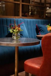 a table with a vase of flowers on it at The White Hart Hotel Lincoln in Lincoln