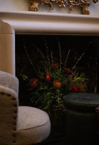 a fireplace with a flower arrangement in front of it at The White Hart Hotel Lincoln in Lincoln