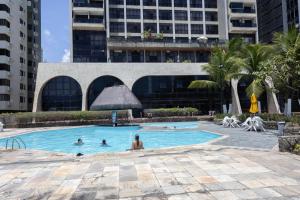 un grupo de personas en una piscina en un edificio en Flat Edf Golden Beach, en Recife