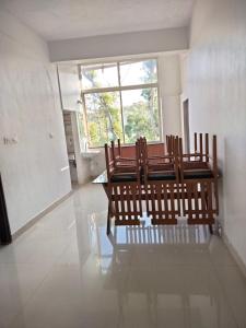 a group of benches in a room with a window at Sana Estate Stay in Madikeri
