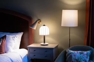 a bedroom with a bed and a lamp and a chair at The White Hart Hotel Lincoln in Lincoln