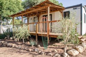 a tiny house with a deck in a yard at Camping Site de Gorge Vent in Fréjus