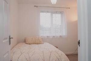 a small bedroom with a bed and a window at BrumStay UK - 2 Bed Flat with secure, allocated parking and fibre broadband with speed upto 120mbps in Birmingham