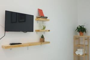 una TV a schermo piatto appesa a una parete di HOTEL VĂN THÁI BÌNH a Trà Vinh Altre 14 foto