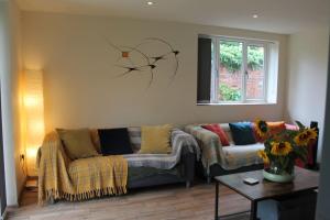 a living room with a couch and a window at The Walled Garden in Long Melford