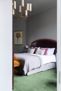 The White Hart Hotel Lincoln في لينكولن: غرفة نوم بسرير كبير مع سجادة خضراء