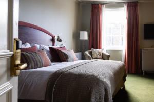 ein Schlafzimmer mit einem großen Bett und einem Fenster in der Unterkunft The White Hart Hotel Lincoln in Lincoln
