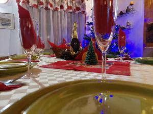 a table with wine glasses on a table with christmas decorations at Family House in Buşteni