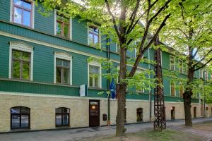 un edificio verde con árboles delante de él en Janne Hotel, en Riga