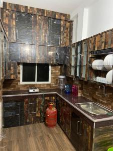 eine Küche mit Holzschränken und einem Waschbecken in der Unterkunft Vaidhya homes in Deoghar
